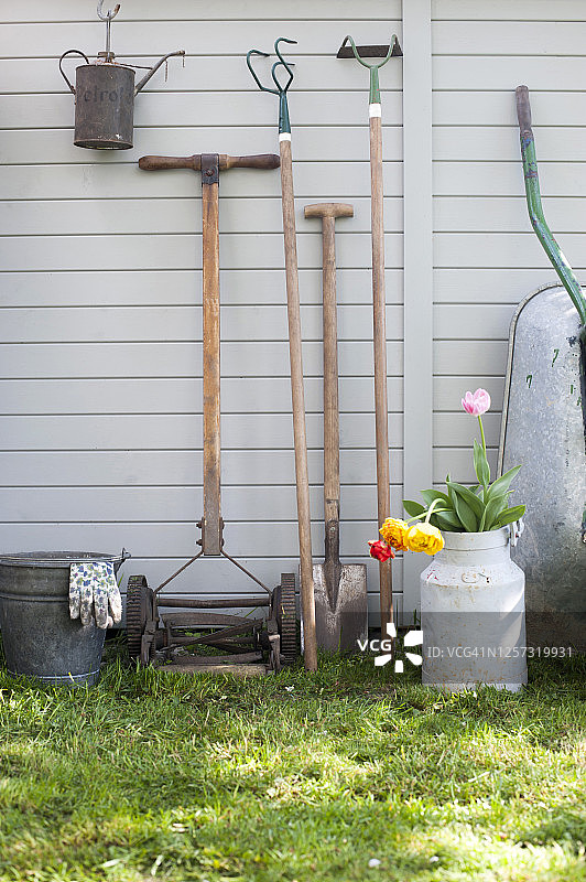 靠在棚屋外墙上的各种园艺工具图片素材