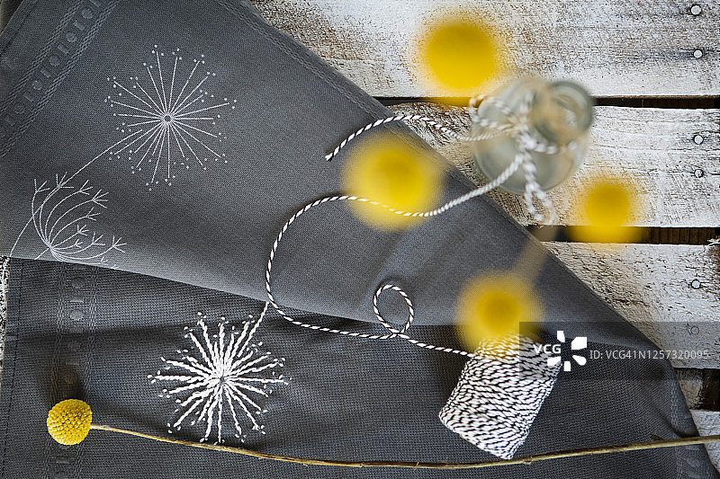 绣花面料和插满金槌花的瓶子图片素材