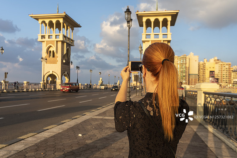 埃及亚历山大：日落时分拍摄斯坦利桥的女子背影图片素材