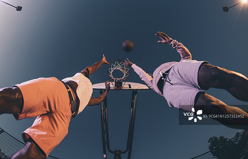 男性朋友在周末夜晚的晴空下打篮球图片素材