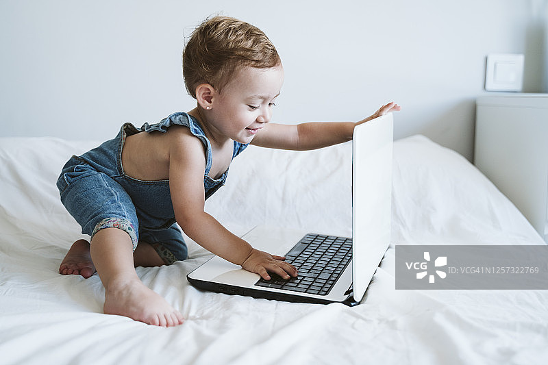 女婴在家使用笔记本电脑图片素材