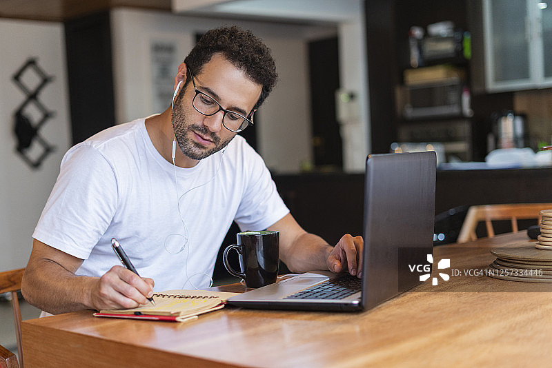 隔离期间在家用笔记本电脑学习的男人肖像图片素材