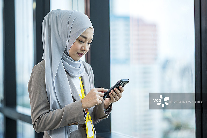 年轻的穆斯林女商人使用手机进行商务活动图片素材