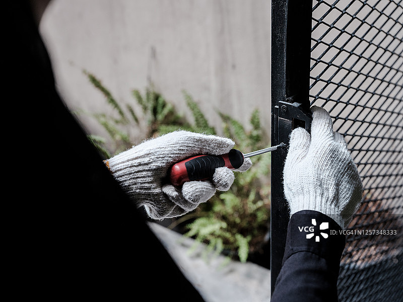 戴着白色手套的手用螺丝刀拧紧螺丝图片素材