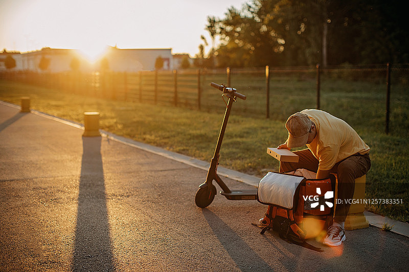 快递员骑电动滑板车派送包裹图片素材