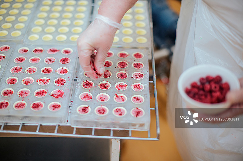 在模具中的松露上撒覆盆子碎图片素材