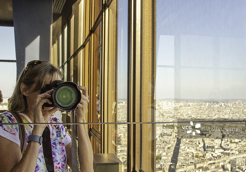 游客在蒙帕纳斯大厦顶部用大型相机拍照图片素材