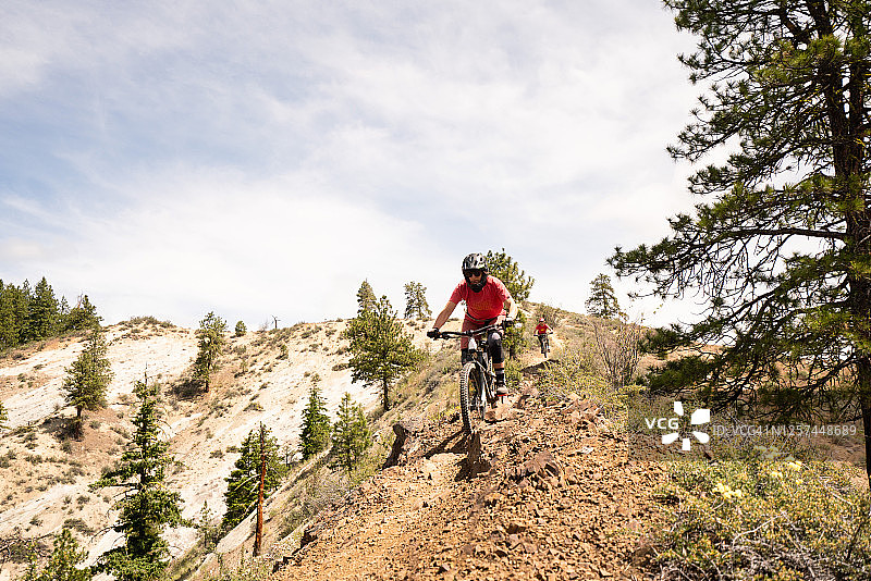 骑山地自行车的女人在山脊小路上骑车，与朋友一起骑行图片素材