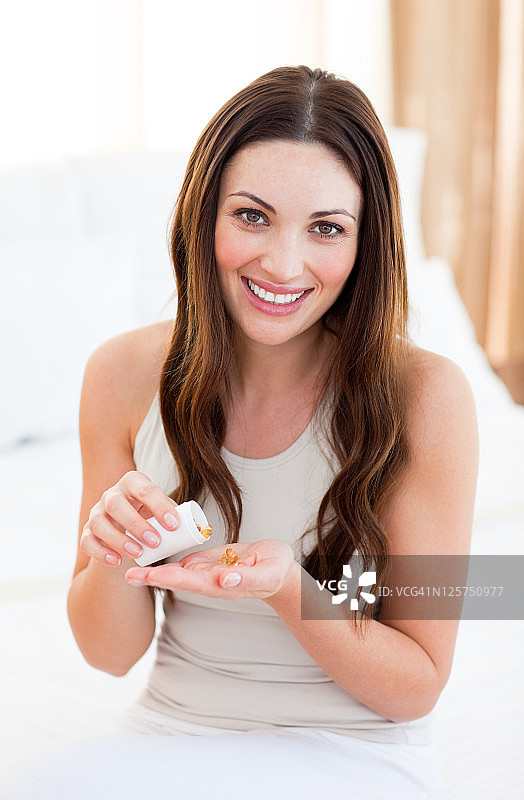 坐在床上吃药的漂亮女人图片素材