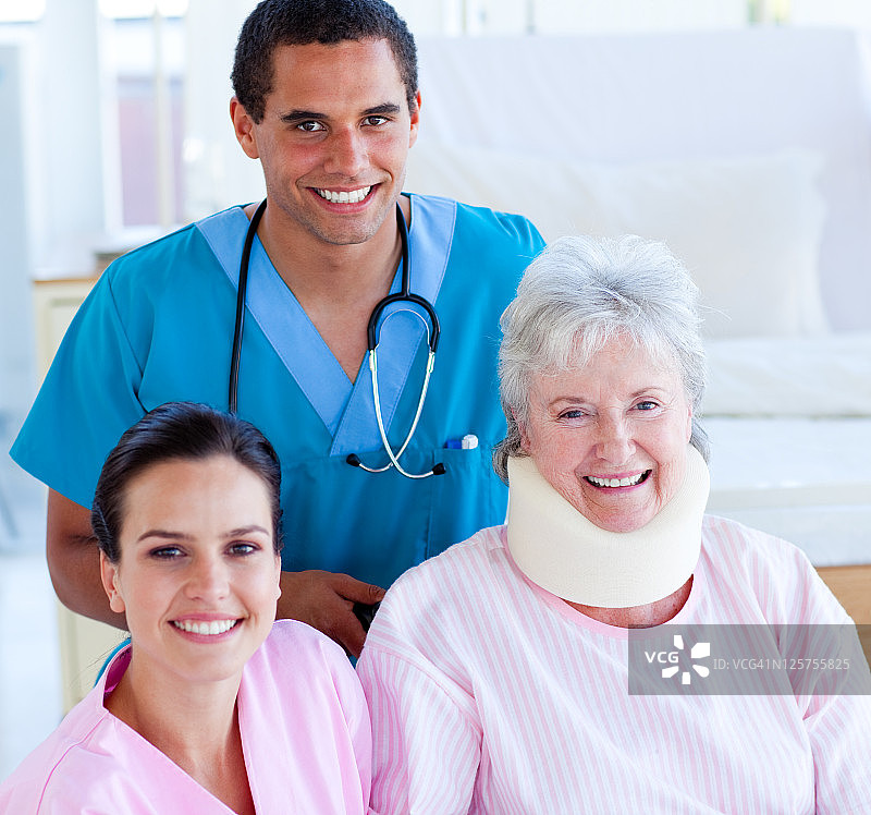 两位笑容满面的医生照顾受伤的老年妇女图片素材