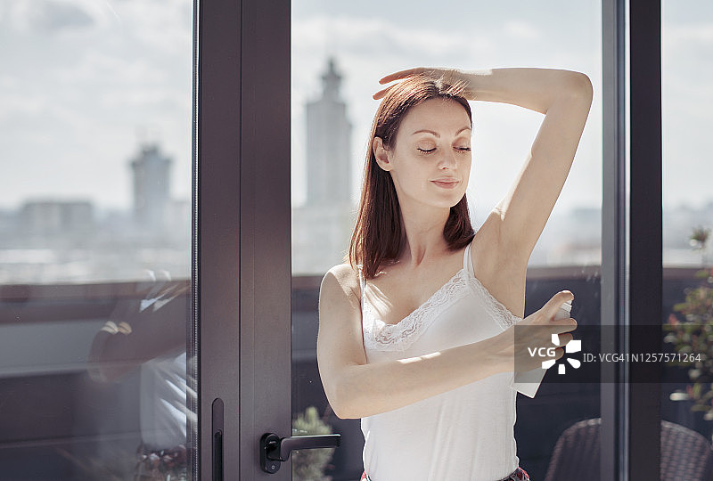 女孩使用除臭剂喷腋下图片素材
