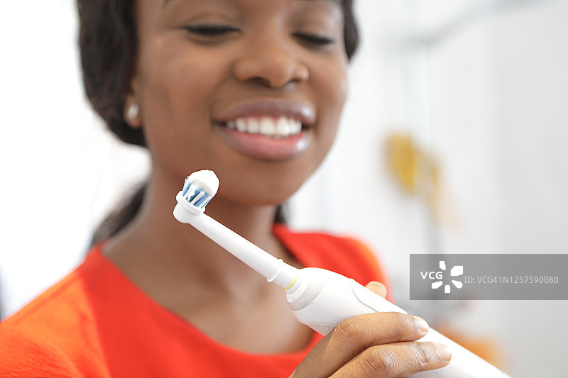 女人用电动牙刷刷牙图片素材