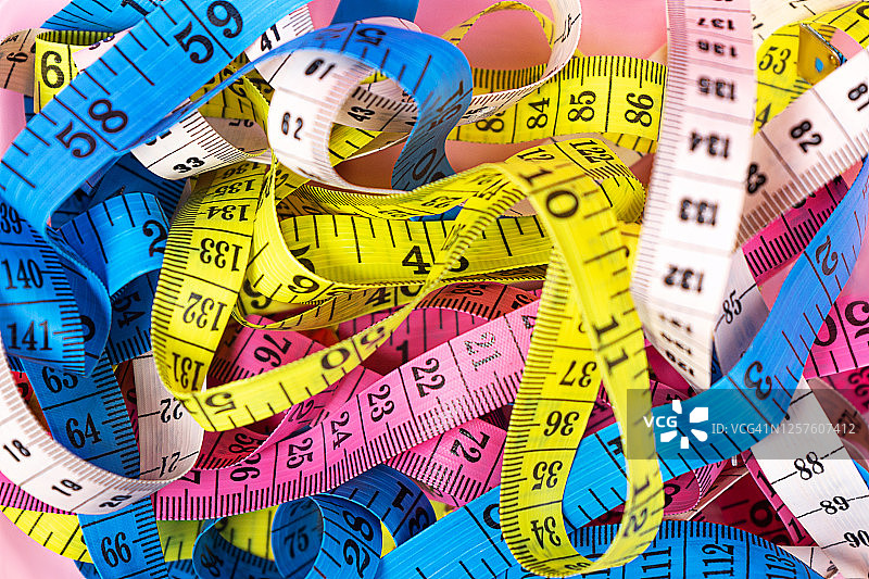 粉色背景上的彩色卷尺图片素材