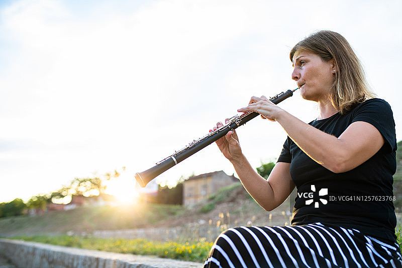在户外吹奏双簧管的女人图片素材