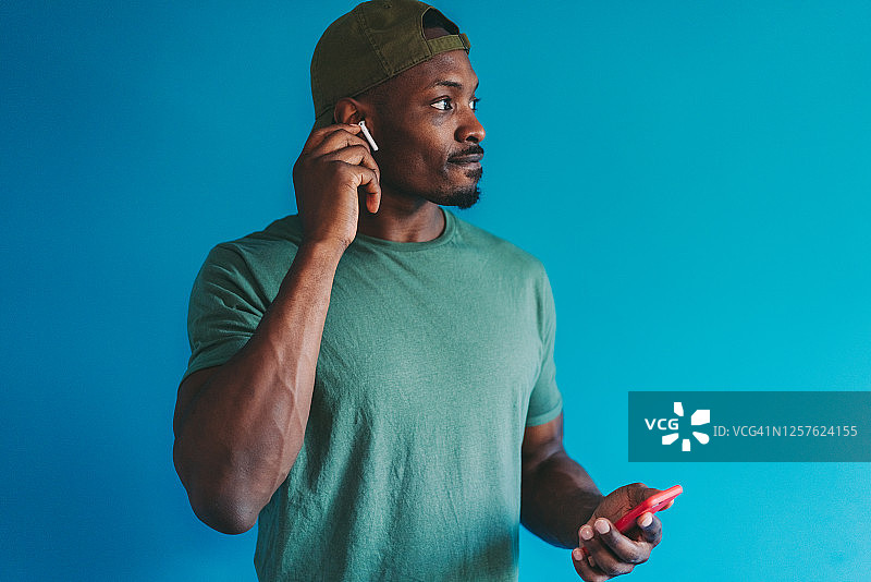 男人轻触无线入耳式耳机接听电话图片素材