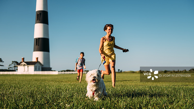 姐弟遛马尔济斯犬图片素材