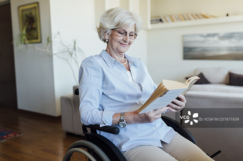 阅读书籍的年长的白人残疾妇女图片素材