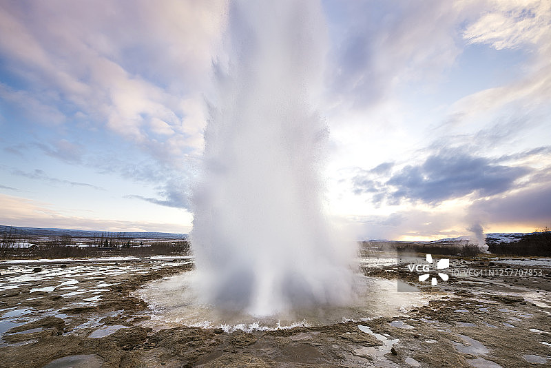 日出时喷发的间歇泉图片素材