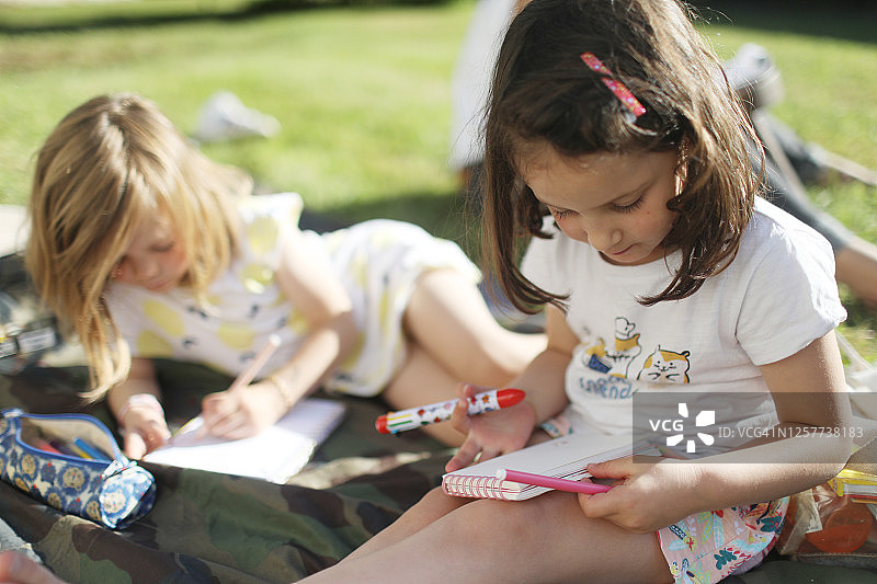 两个小女孩在花园里画画图片素材