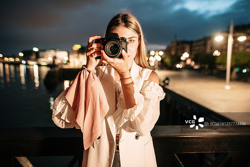 年轻女人使用大型单反相机图片素材