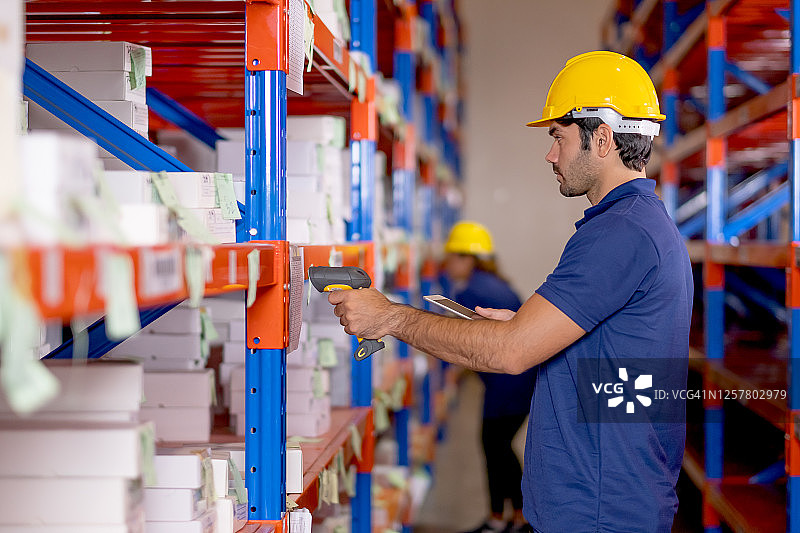 仓库男工人用条形码扫描器检查货架上的产品库存图片素材