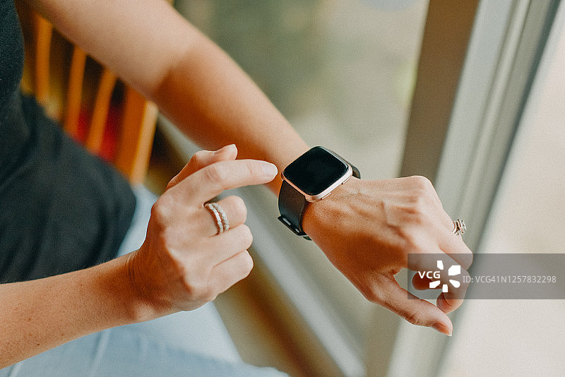 手腕上戴着智能手表的年轻白人女性图片素材
