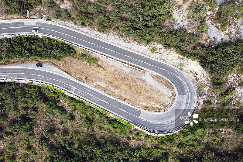 绿色松树林中高山隘口蜿蜒道路的鸟瞰图。优质照片图片素材