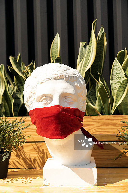 红色布防护面罩下的石膏人体模型特写图片素材