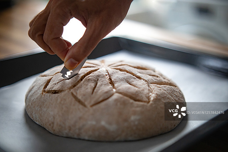 手用剃须刀片给全麦面包评分图片素材