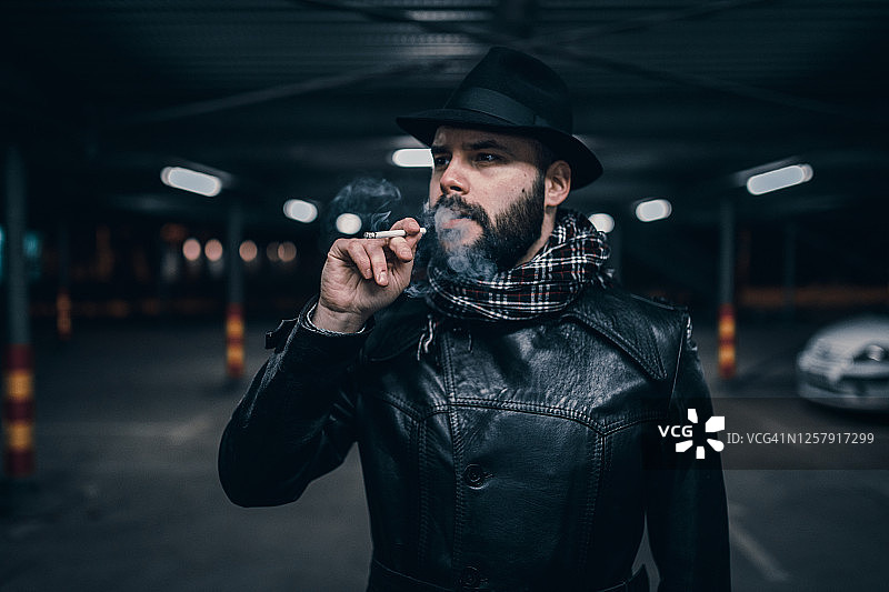 在停车场抽烟的年轻男人图片素材