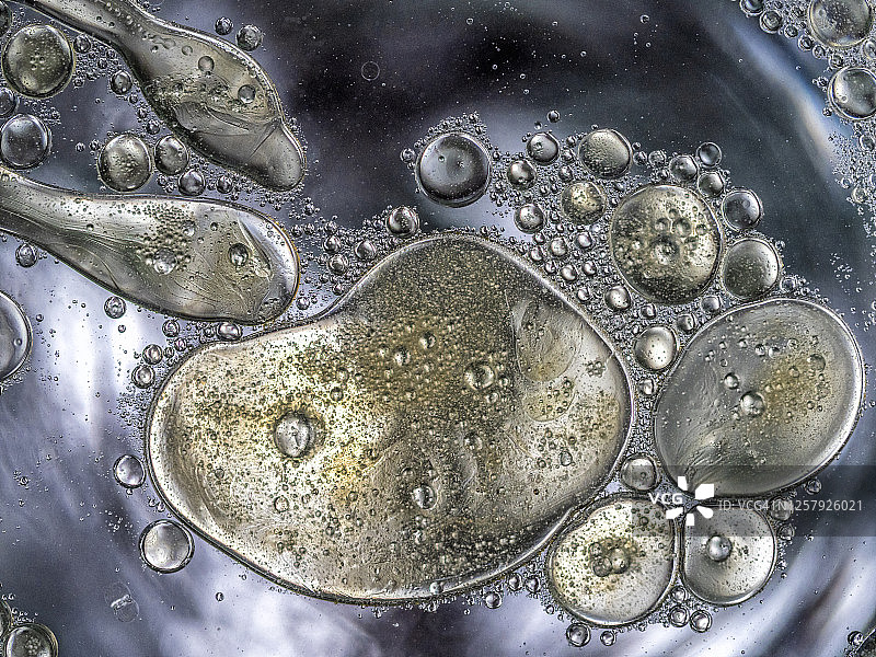 金色液体背景上的气泡和水滴纹理抽象形状图片素材