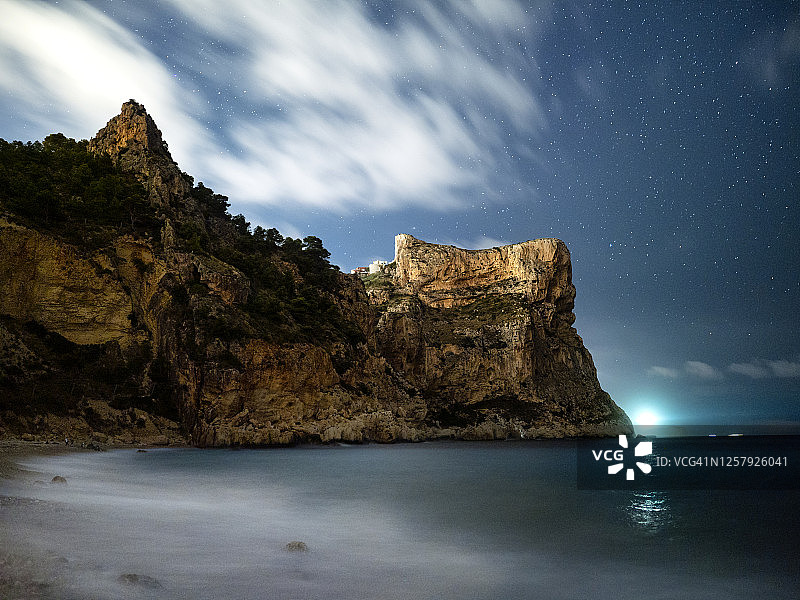 海岸风光：小海滩、岩石峭壁与树木，星云夜空图片素材