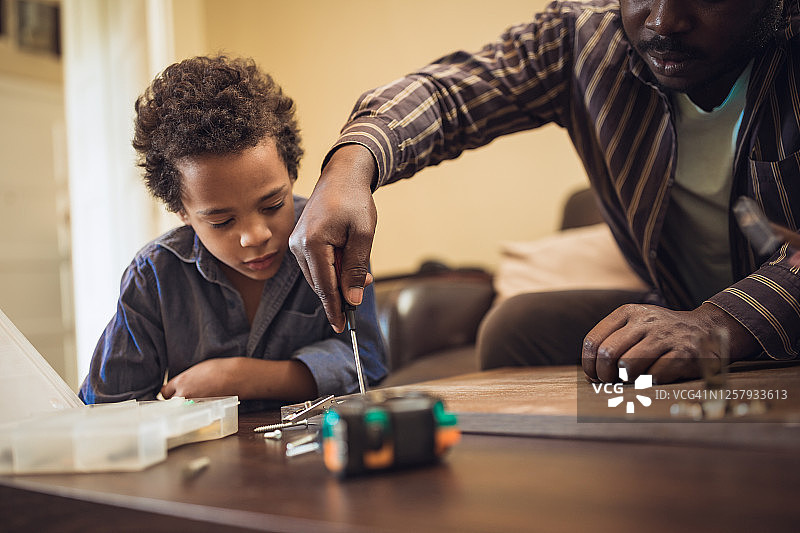 和孩子们一起帮助父亲组装家具图片素材