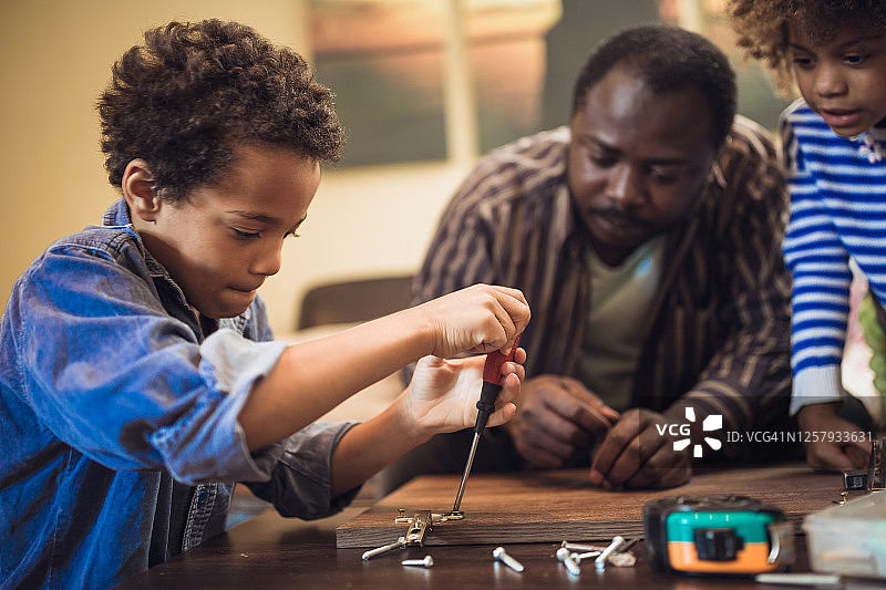 和孩子们一起帮助父亲组装家具图片素材