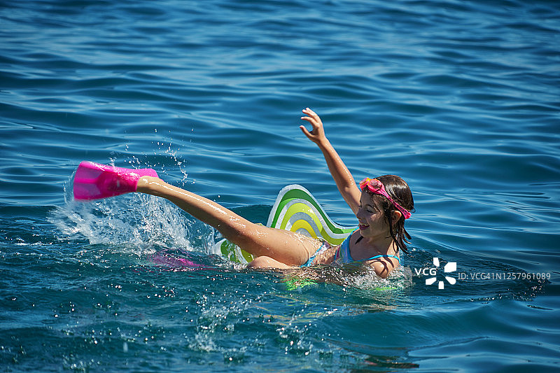 在克罗地亚达尔马提亚地区海滩上，在充气圈上放松的女孩图片素材