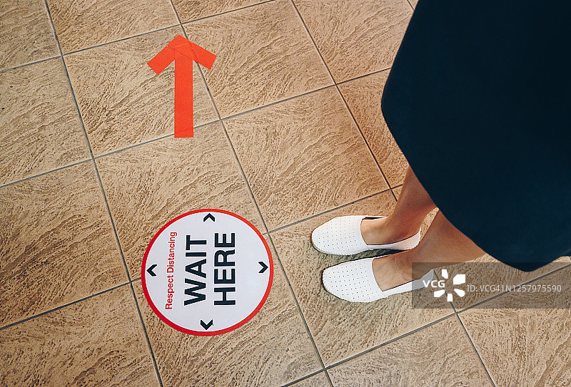疫情期间，遵守社交距离排队等候的女性图片素材