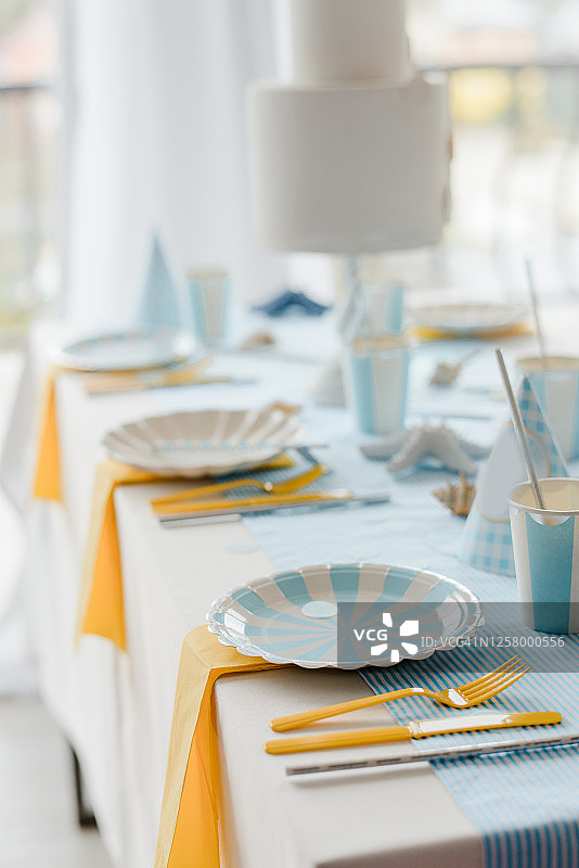 白色餐具黄色刀叉蓝色桌布的室内装饰和餐桌布置图片素材