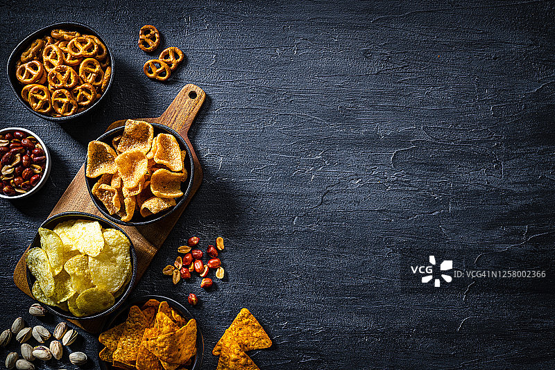 深色石板桌上的咸味零食图片素材
