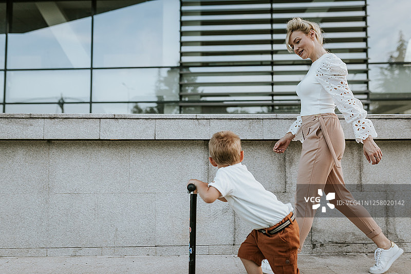 母亲教儿子如何骑滑板车图片素材