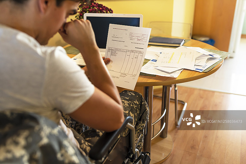 坐轮椅的退伍士兵无力支付账单图片素材