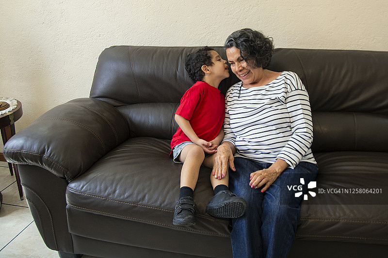 祖母和孩子坐在家里的沙发上图片素材