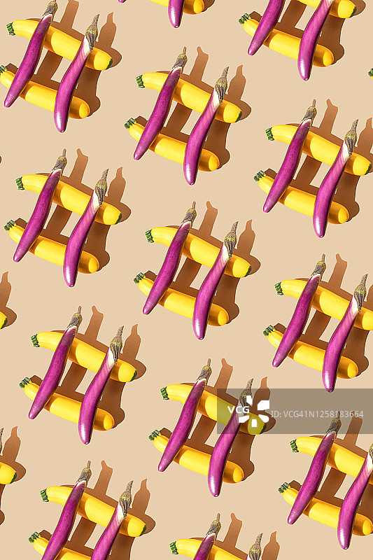 金色西葫芦和紫色茄子在米色背景上组成井号图片素材