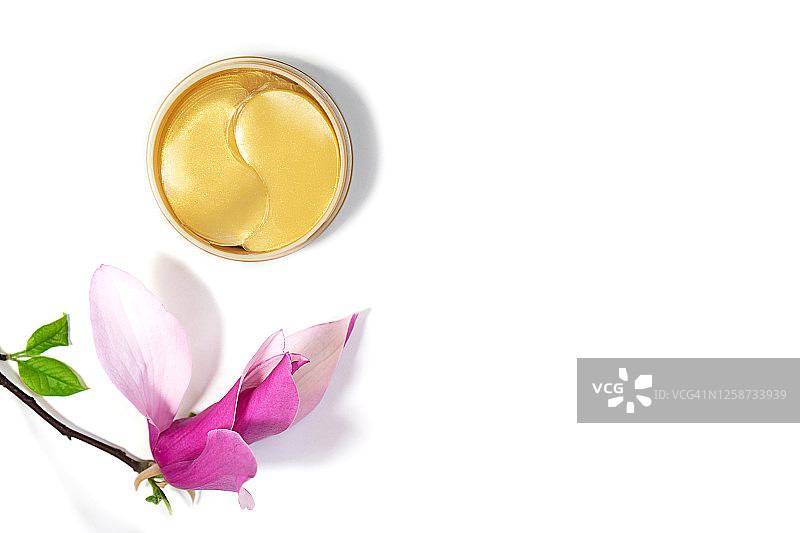 白色背景上的金色眼膜和玉兰花图片素材