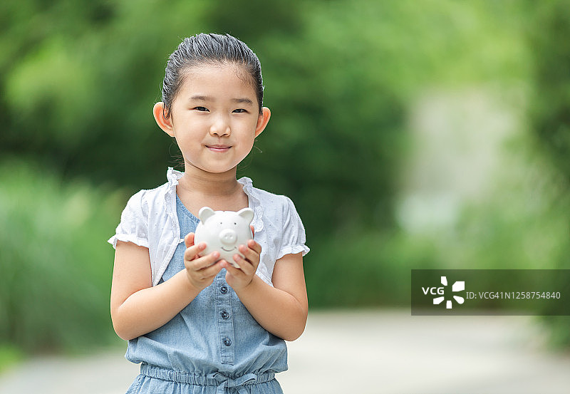 可爱小女孩手持存钱罐图片素材
