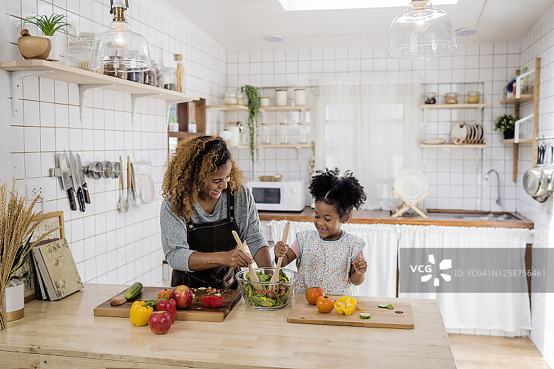 女孩向母亲学习做饭图片素材
