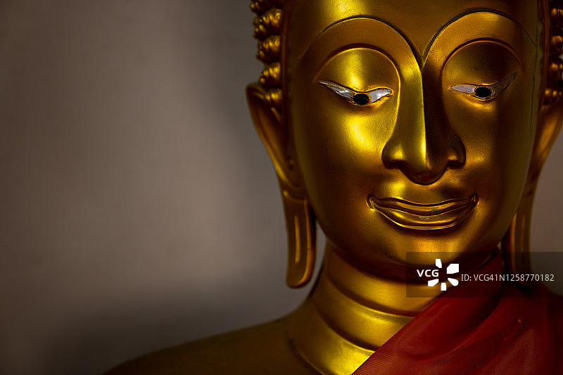 泰国阿瑜陀耶寺庙金色佛像头部微笑面容。佛教中的佛像被认为是亚洲佛教徒的宗教、冥想和意识的象征。图片素材