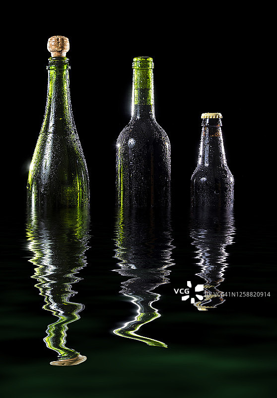 葡萄酒、啤酒和香槟在黑色背景的水面上反射图片素材