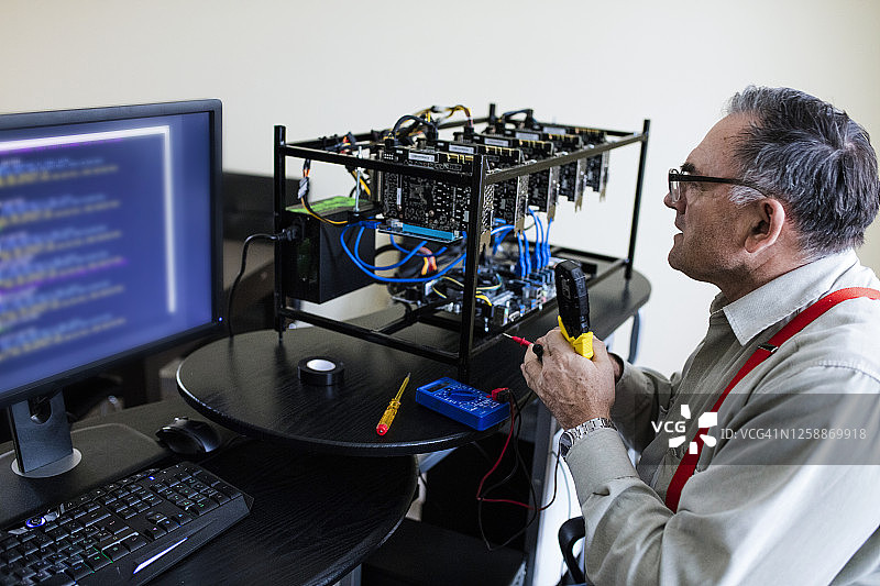 年长的工程师设置GPU矿机图片素材