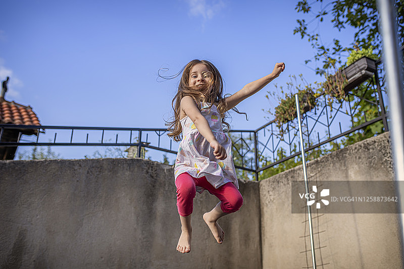 漂亮女孩在蹦床上跳跃图片素材