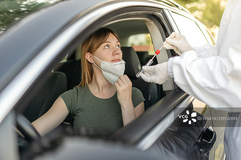 医生在公共建筑前从汽车司机身上取拭子图片素材